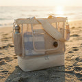 Bolso Médano 2 en 1 color crema con compartimento térmico, sobre la arena al atardecer